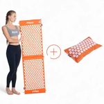 Femme tenant un tapis Magnetic Mysa orange à deux panneaux à côté du coussin ThermoMag