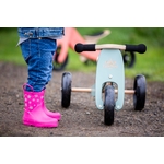 Enfant utilisant un tricycle Kinderfeets Tiny Tot en extérieur pour développer équilibre et motricité dès 12 mois
