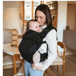 Néo+ Néobulle coloris NoirÉbène, porté devant, bébé souriant en intérieur