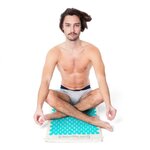 Homme assis en tailleur sur le tapis d’acupression Climsom Zen bleu