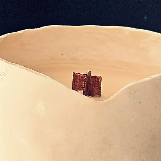 Détail de la mèche en bois croisée sur une bougie coquille éco-conçue, témoignant du savoir-faire artisanal et de la qualité des matières.