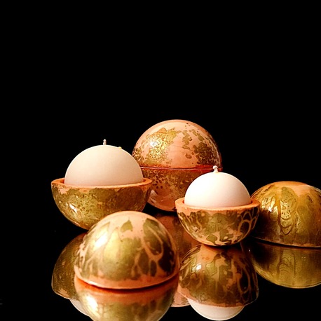 Composition de bougies globes Classic ouverts laissant apparaître une cire blanche parfumée à la fleur d'oranger, dans des contenants artisanaux couleur abricot aux finitions dorées élégantes