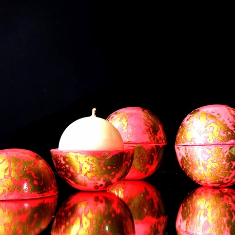 Duo de bougies globes Classic ouvertes, cire végétale parfum pivoine, contenants artisanaux rose fluo avec motifs dorés éclatants sur fond noir.