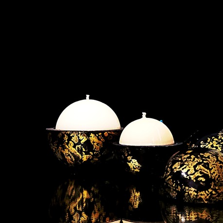 Bougies globes Classic artisanales couleur noir aubergine aux reflets dorés, laissant découvrir une cire blanche parfumée au bois de tonka.