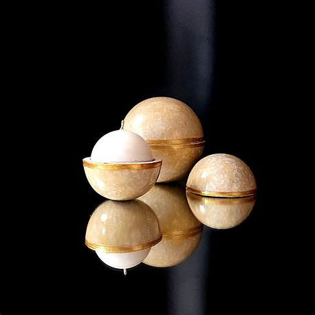 Bougie globe Bollywood ouverte laissant apparaître une cire végétale parfum safran boisé, contenant moucheté gris perle et ocre jaune souligné d'un liseré doré.