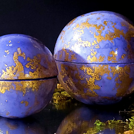 Gros plan sur deux bougies globes Classic parfumée à la lavande, contenants bleu lavande mouchetés d'or 