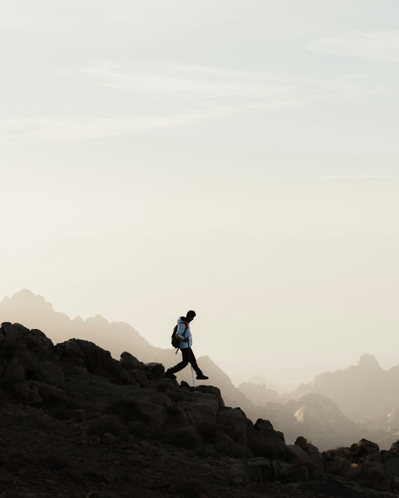 Coureur sur une arête rocheuse dans la brume des Alpes