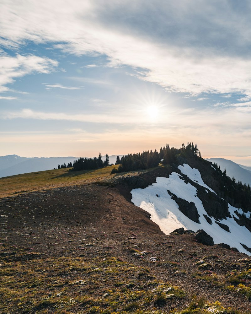 Crête enneigée balayée par le vent au soleil couchant