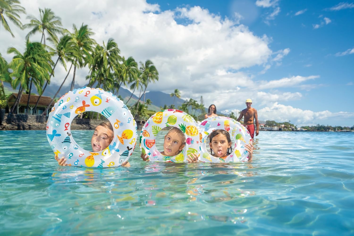 Enfants flottant dans des bouées imprimées dans une eau turquoise