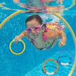 Enfant avec lunettes nageant sous leau vers des anneaux de plongée