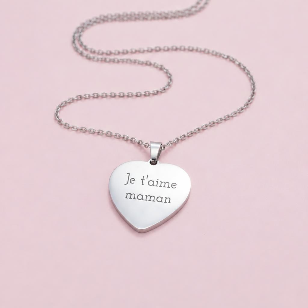 Collier coeur argenté gravé Je taime maman posé sur fond rose