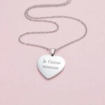 Collier coeur argenté gravé Je taime maman posé sur fond rose