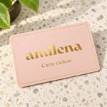 Carte cadeau Amilena rose avec logo doré posée sur un plan en terrazzo
