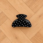 Pince noire à pois sur parquet clair