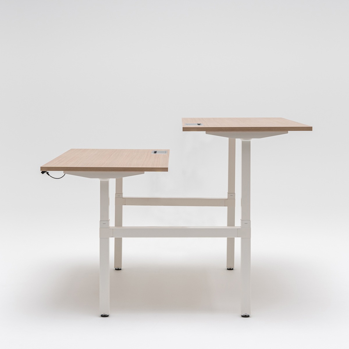 Bureau bench Ogi Drive Bench vu de côté, deux plateaux réglés à des hauteurs différentes, structure blanche