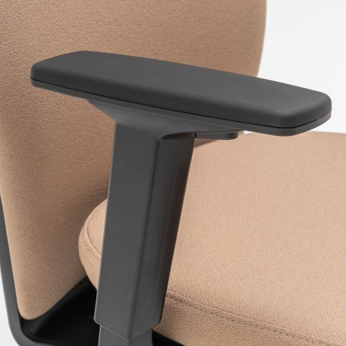 Accoudoir à manchette noire sur une chaise de bureau tapissée beige, vue de détail