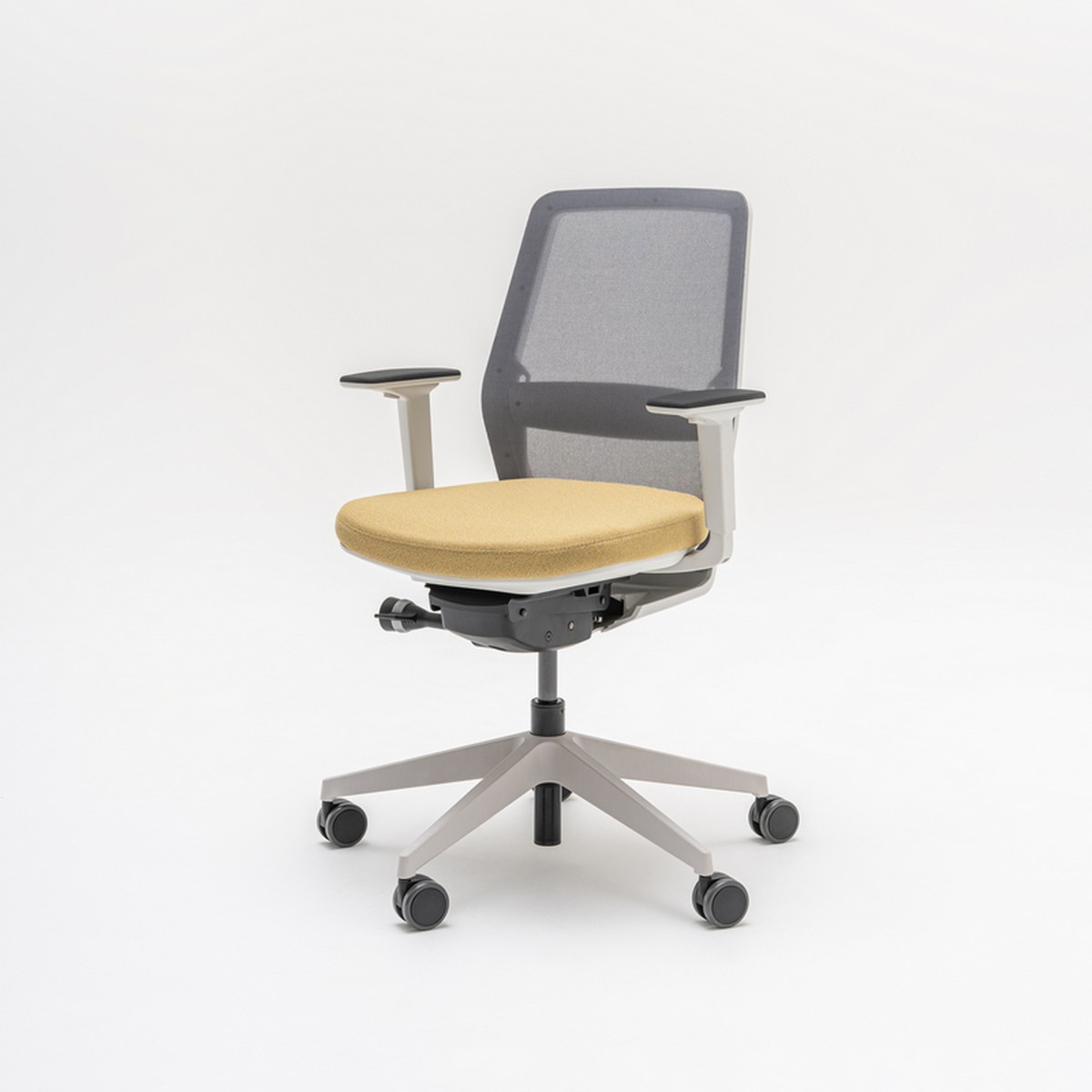 Chaise de bureau à dossier résille grise, assise jaune et piétement gris clair, vue de trois quarts