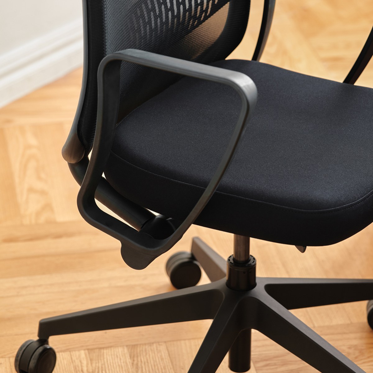 Accoudoir fixe, assise tapissée et piètement cinq branches noir de la chaise de bureau Astro