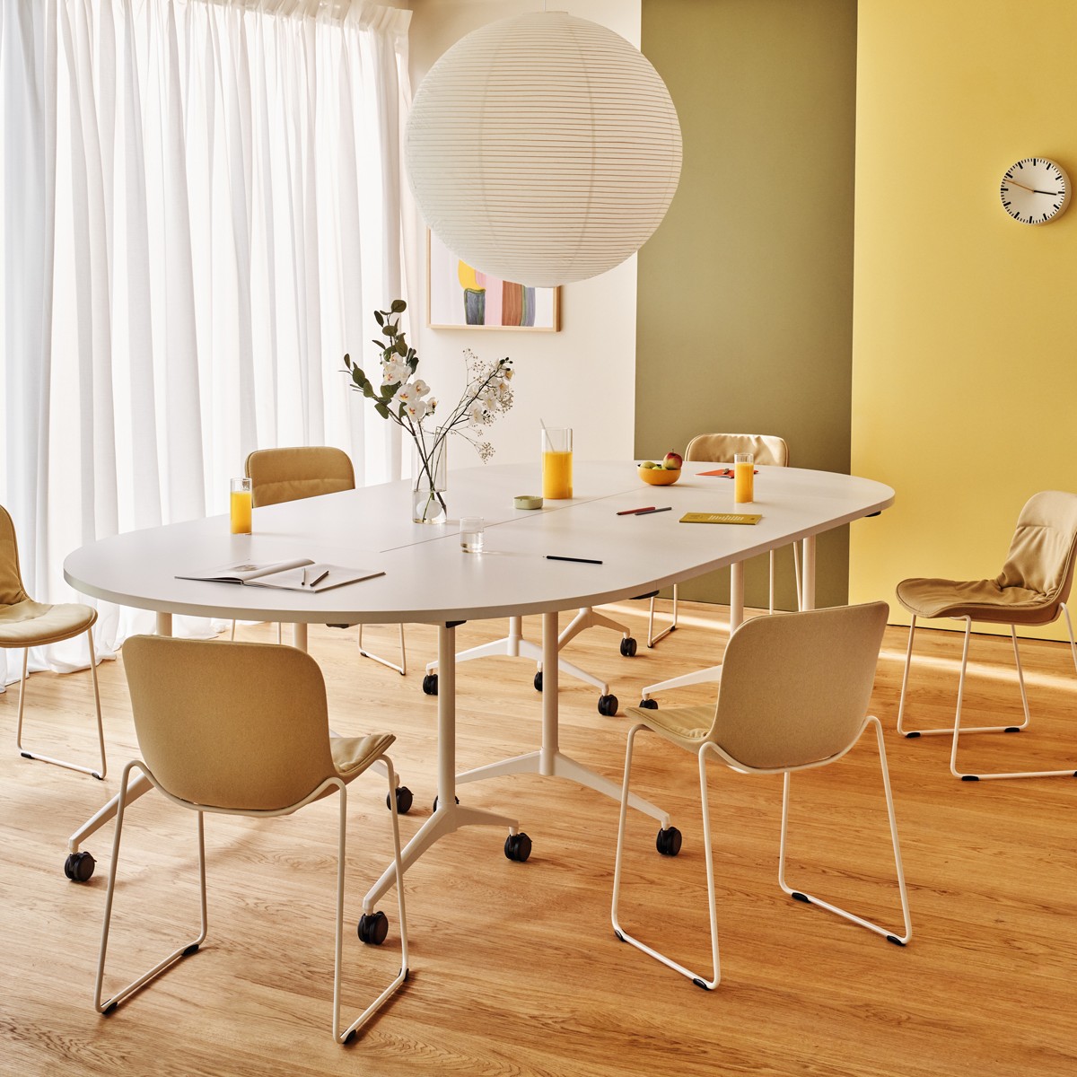 Table de réunion Revi ovale blanche, plusieurs plateaux assemblés, dans une salle claire avec chaises