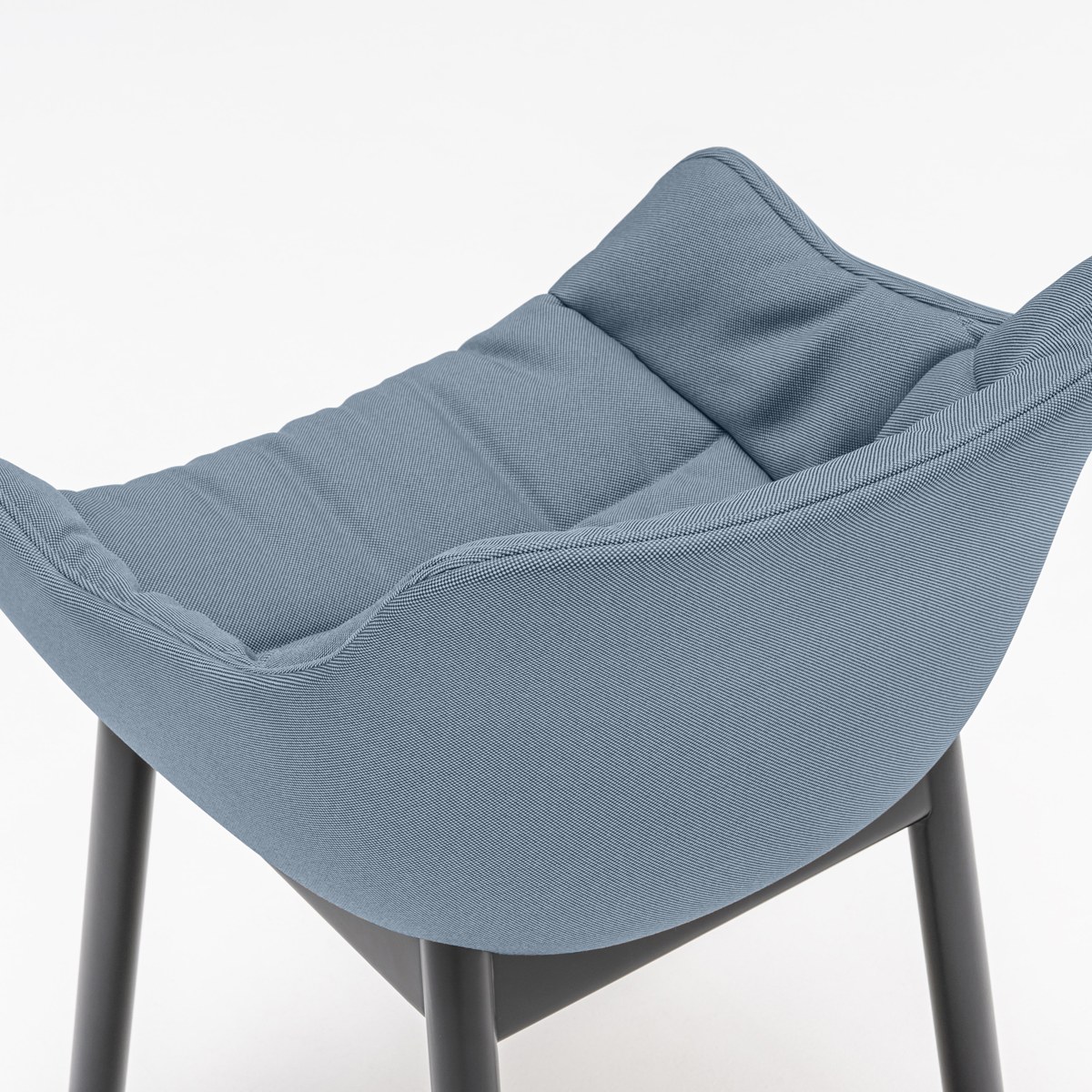 Fauteuil bleu-gris à coussin drapé vu de dessus, accoudoirs intégrés à la coque