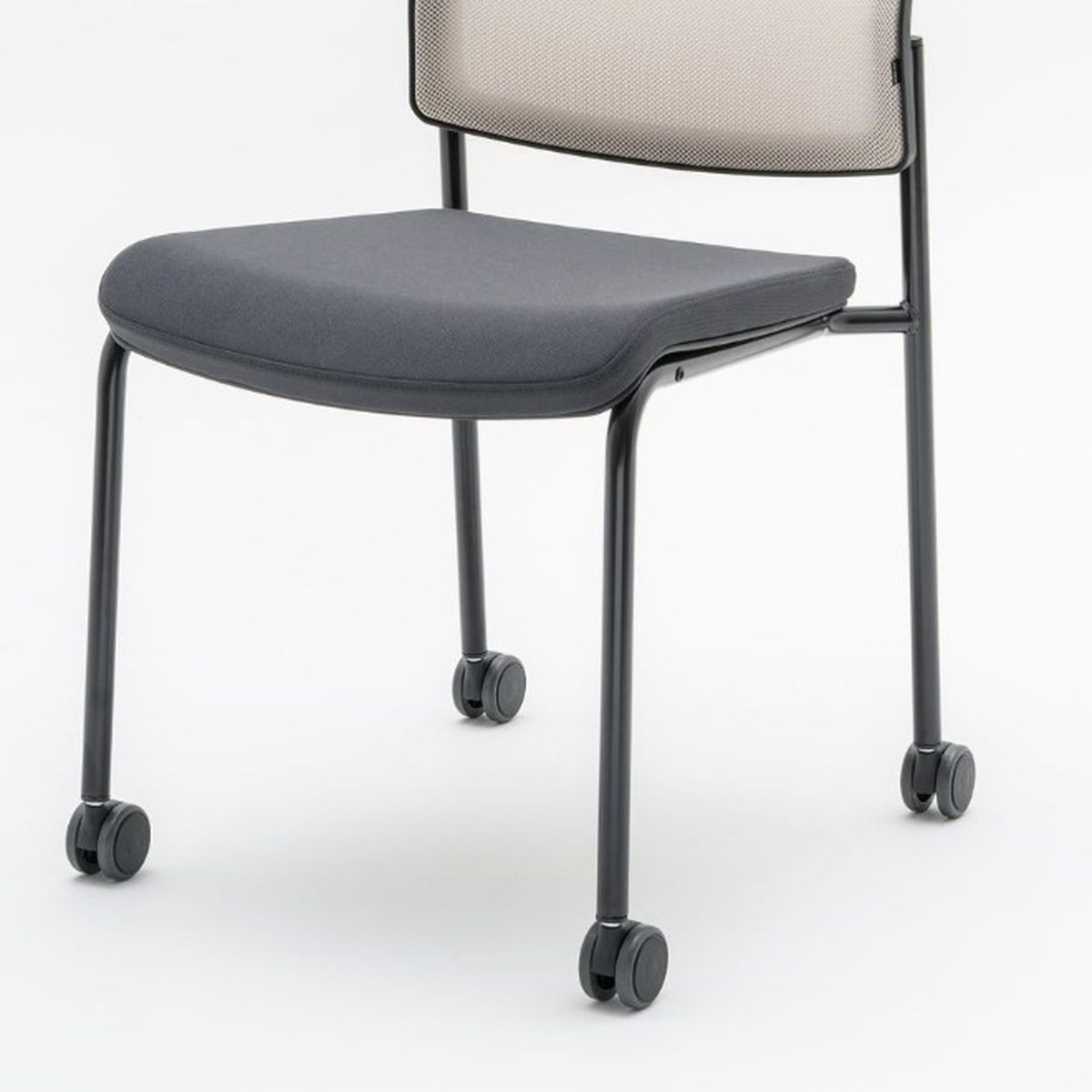 Détail de lassise tapissée graphite et des pieds noirs à roulettes de la chaise Gaya