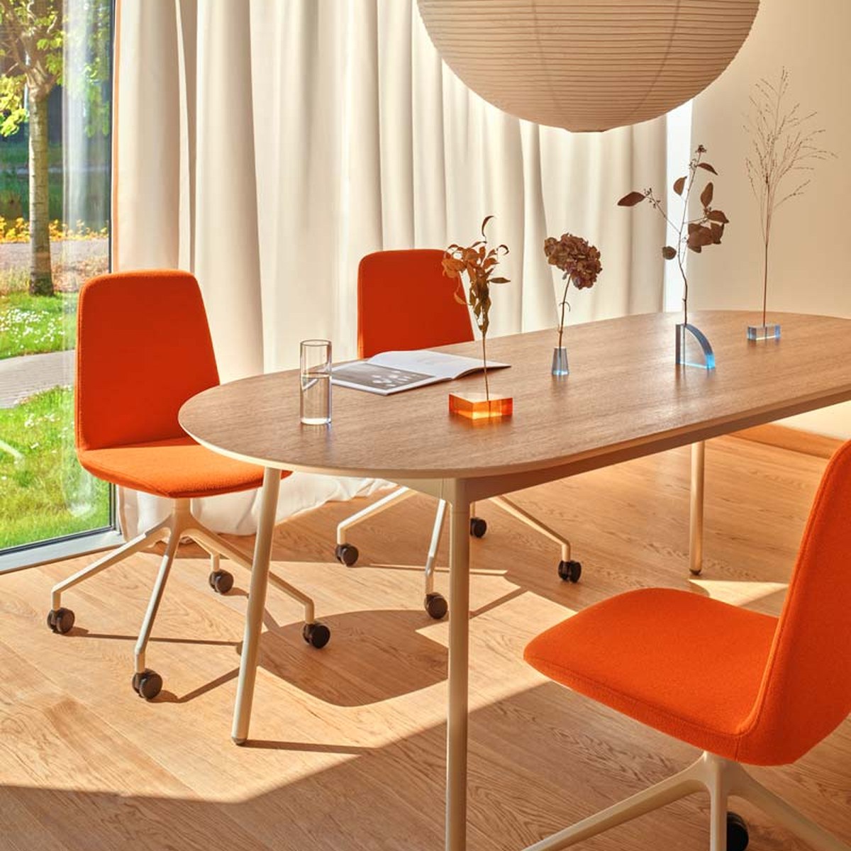 Chaises de réunion pivotantes à roulettes Ulti orange autour dune table ovale