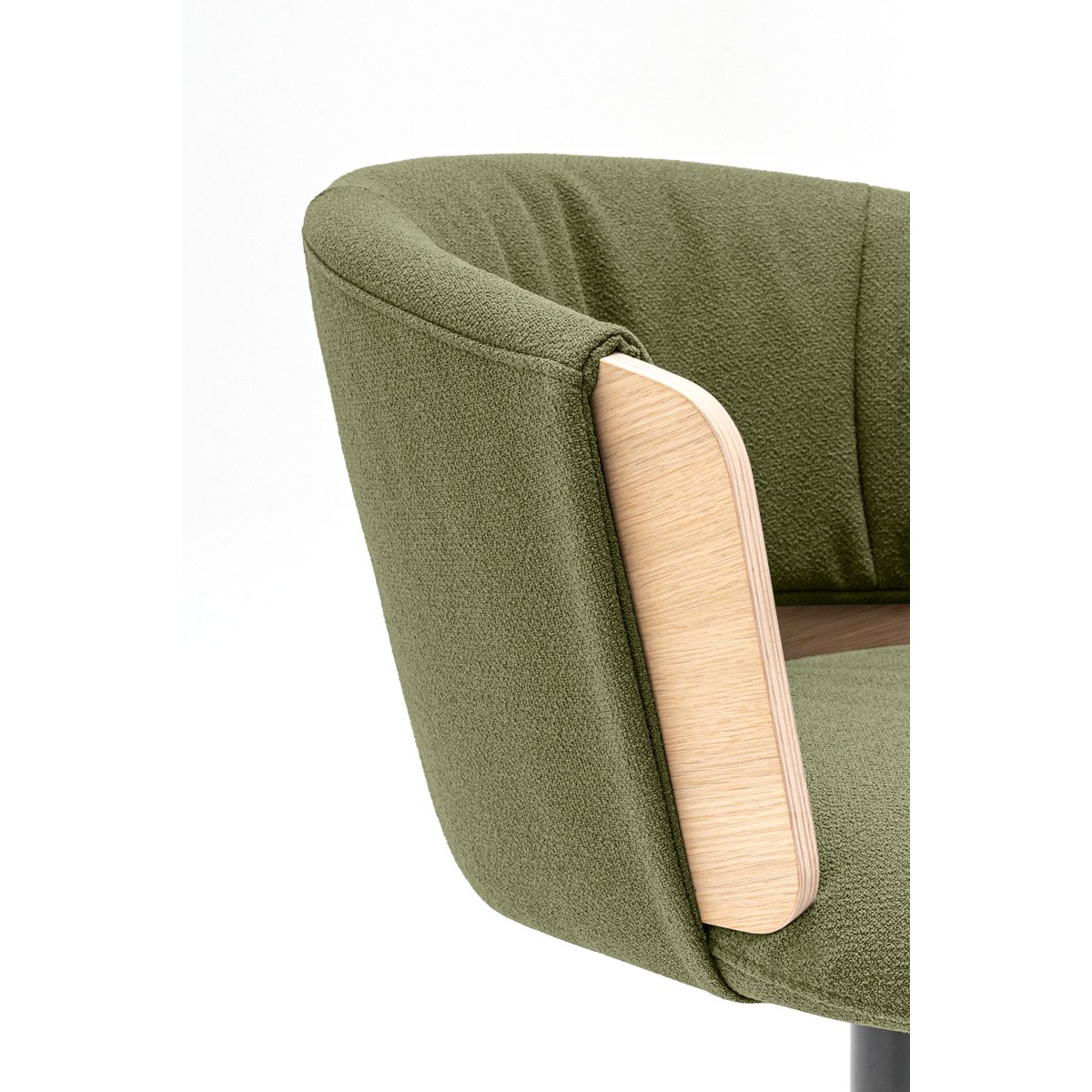 Détail du coussin plissé vert et du flanc plaqué chêne naturel du siège