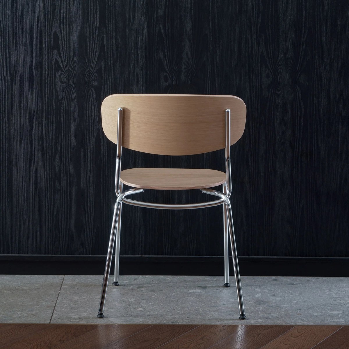 Chaise Splot en chêne naturel sur structure chromée, vue de dos avec pieds croisés
