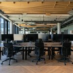 Bureaux doubles assis-debout Ogi Drive à plateaux sombres et structure noire dans un grand open space