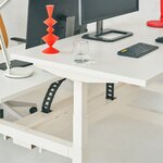 Chaînes de câbles sortant du chemin de câbles partagé sous un bench Ogi Drive blanc, vue sur deux postes