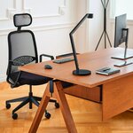 Chaise de bureau Astro noire à dossier résille et appui-tête, posée devant un bureau en bois
