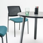 Détail dun pied incliné en acier anthracite et du plateau rond de la table Ogi A