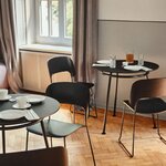 Tables rondes New School noires dressées pour un repas, avec des chaises en bois noir