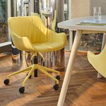 Chaise réglable jaune à coussin drapé sur parquet à côté dune table blanche