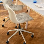 Chaise de bureau Baltic 2 Soft Duo blanche à roulettes devant une table de réunion