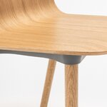 Détail de la coque en contreplaqué chêne naturel et du pied en chêne de la chaise Nud