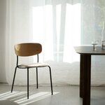 Chaise Splot rembourrée bouclette sable et chêne naturel près dune table en bois