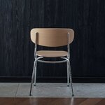 Chaise Splot en chêne naturel sur structure chromée, vue de dos avec pieds croisés