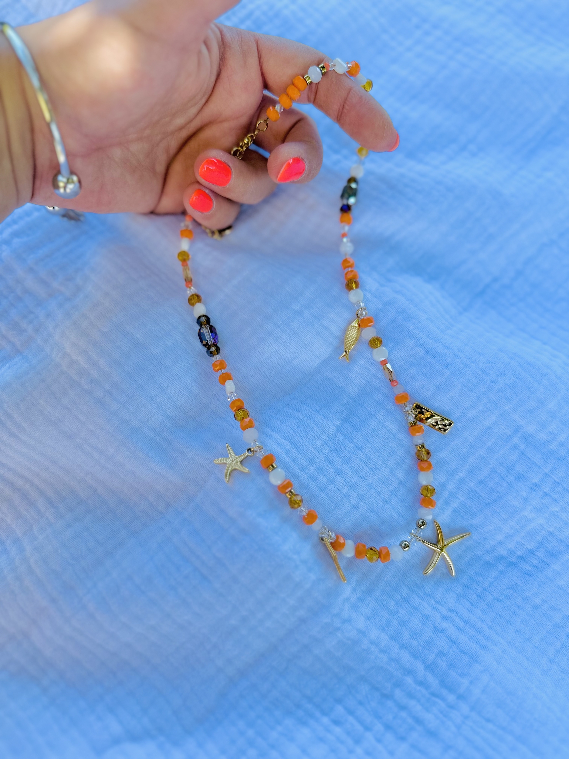 Collier en perles orange avec des breloques