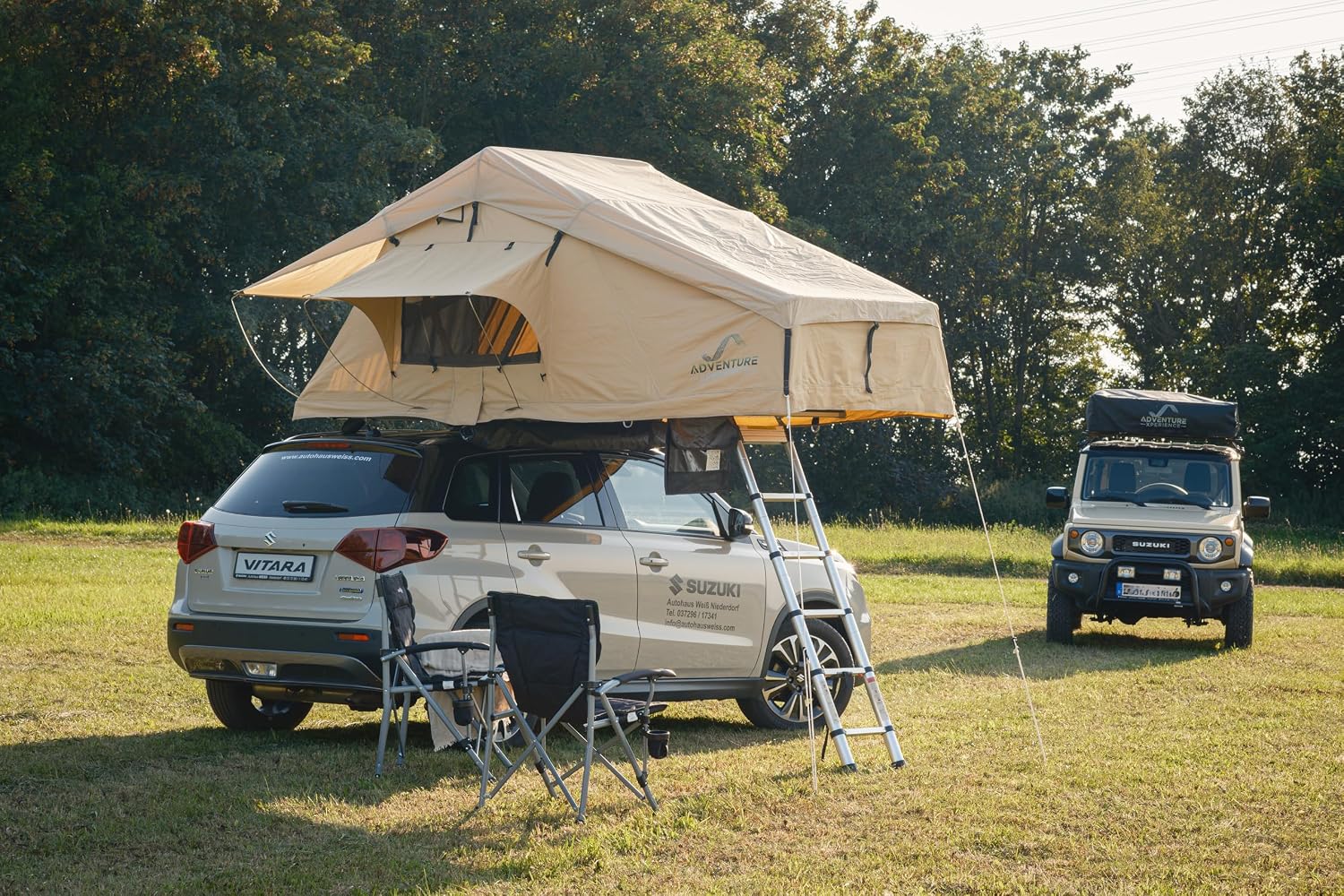 Tente de toit AdventureMate140 ouverte sur un SUV, chaises de camping devant