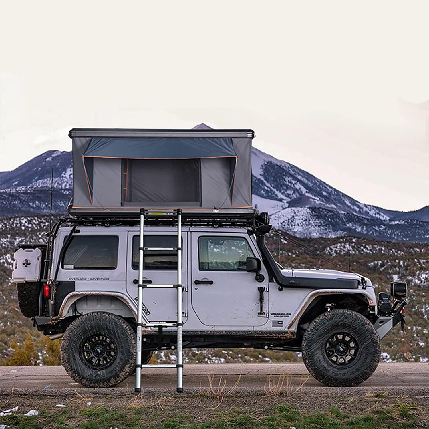 Tente XTLLY ouverte sur un Jeep au pied d'une montagne enneigée, échelle verticale