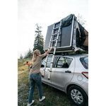 Femme faisant basculer la tente MH500 avec léchelle sur une citadine
