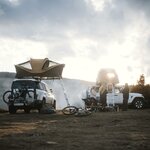 Campement avec vélos et deux véhicules équipés de tentes de toit