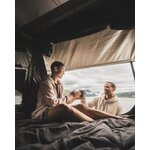 Couple assis dans la tente de toit Quechua x NaïtUp, vue sur un lac