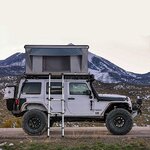 Tente XTLLY ouverte sur un Jeep au pied dune montagne enneigée, échelle verticale