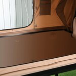 Intérieur de la tente beige : matelas et poche murale