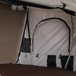 Intérieur de la tente blanche : porte en arc, poches et armature