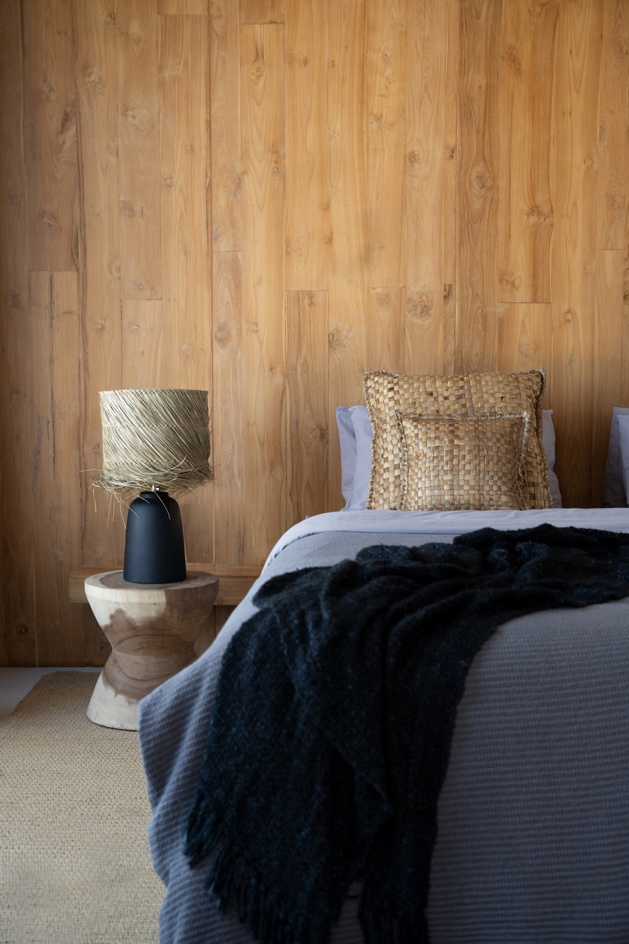 Coussins carrés marrons en jacinthe deau sur un lit dans une chambre