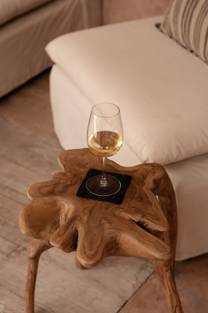 Table Rooty près d’un canapé, avec un verre posé sur le plateau