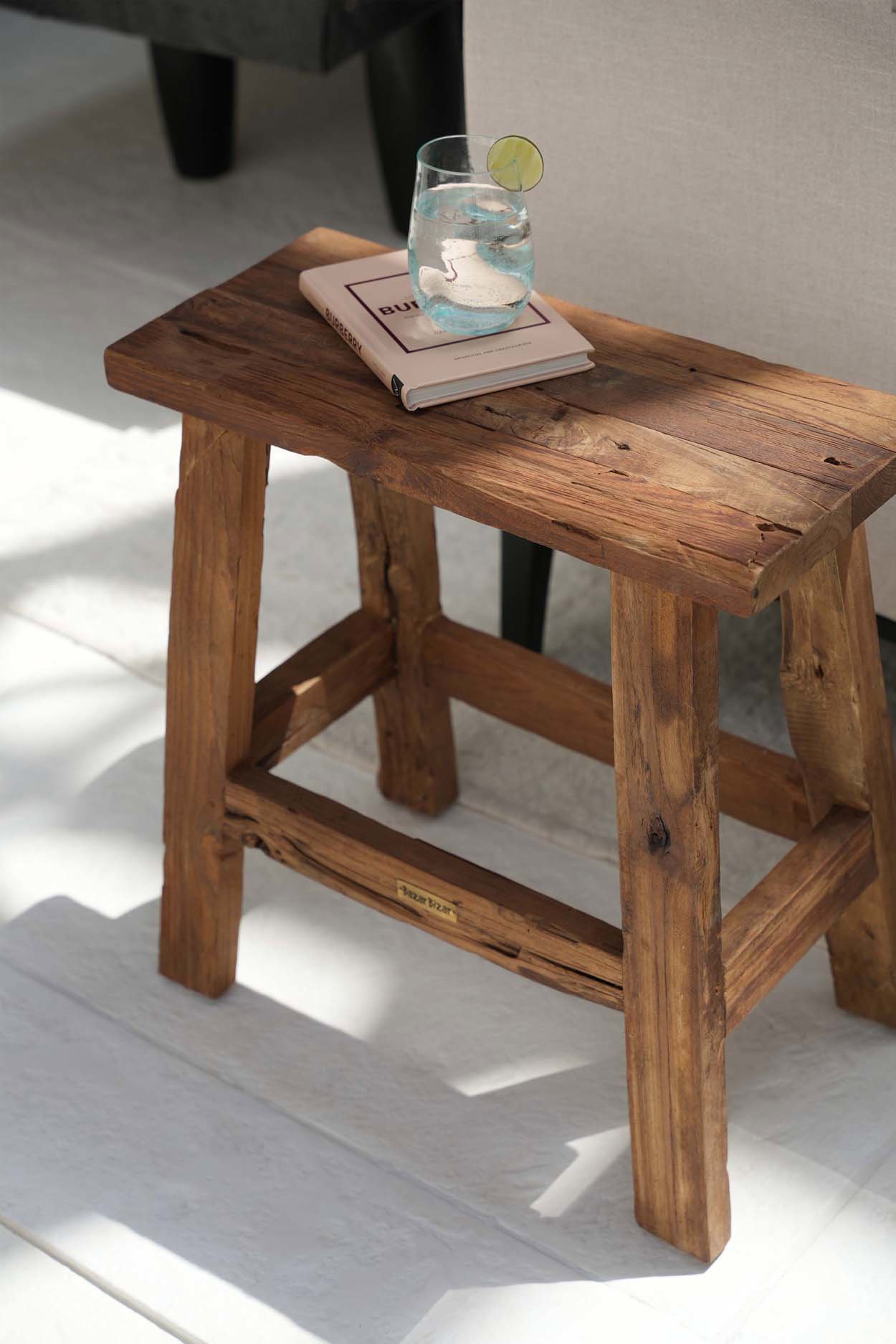 Tabouret Fab Rustic utilisé comme petite table avec un verre posé sur son assise.